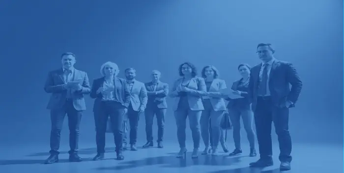 A diverse group of business professionals standing together in a studio setting, representing the collaborative, education‑focused mission of JM Lesko Financial to equip advisors and organizations with financial psychology tools.