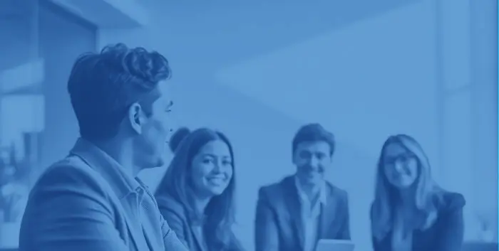 Four business professionals seated around a table in a modern office, engaged in a collaborative discussion that reflects JM Lesko Financial’s commitment to thoughtful, research‑driven financial education.